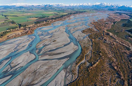 The view from a helicopter of the Waimakariri River and the farmlands of the Canterbury Plain, on New Zealand's South Island, stretching away towards the mighty Southern Alps.