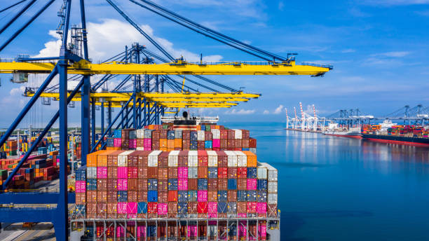 istock Container cargo ship at industrial port in import export business logistic and transportation of international by container cargo ship in the open sea, Aerial view. 1181226307