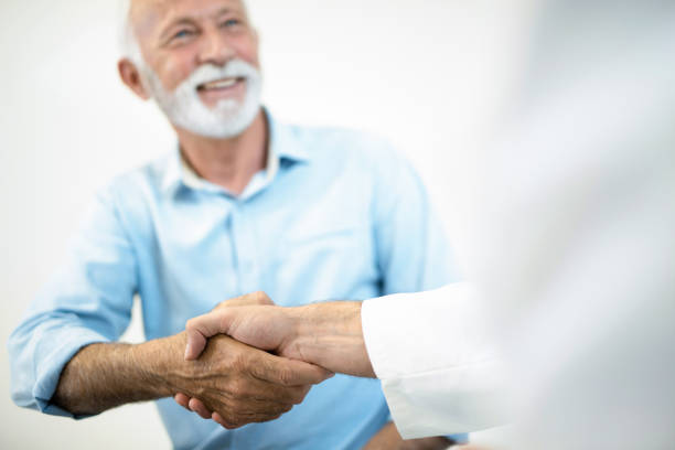 istock Happy senior man shaking hands with doctor. 1181227583