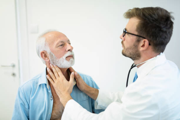 istock Doctor doing throat examination on older man. 1181227728