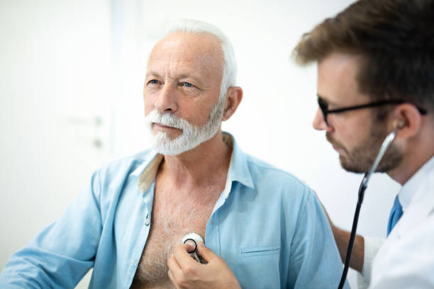 un anciano que le examinaron el corazón con estetoscopio en el hospital. - chest stethoscope medical exam men fotografías e imágenes de stock