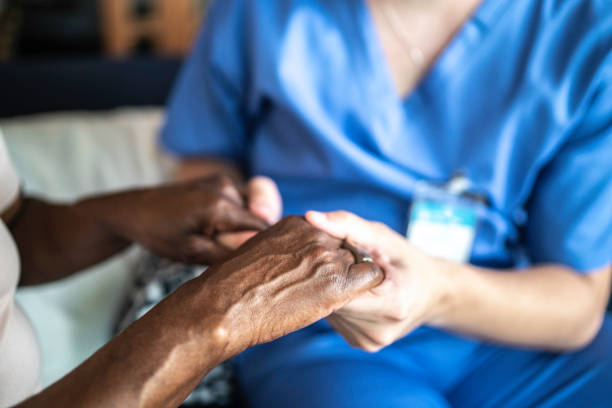 primer plano del cuidador en el hogar y de la mujer de la tercera edad que se está tomando de la mano - holding hands human hand senior adult consoling fotografías e imágenes de stock