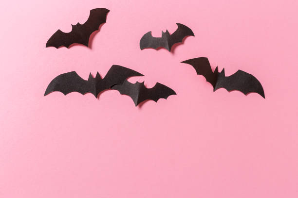 istock Halloween crafts, paper ghost on pink paper background with copy space for text. halloween concept. 1181229298