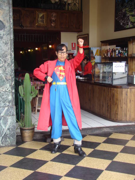 Street Entertainers in Lima, Peru Lima, Peru - May 27, 2007: Photo of a man dressed in Superman costume in the streets of the capital city of Peru, Lima. He is standing in front of a restaurant and entertaining tourists. super film title stock pictures, royalty-free photos & images