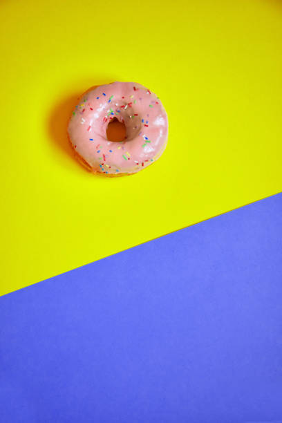 istock Sprinkled pink donut on colorful background. 1181230305