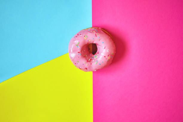 istock Sprinkled pink donut on colorful background. 1181230858