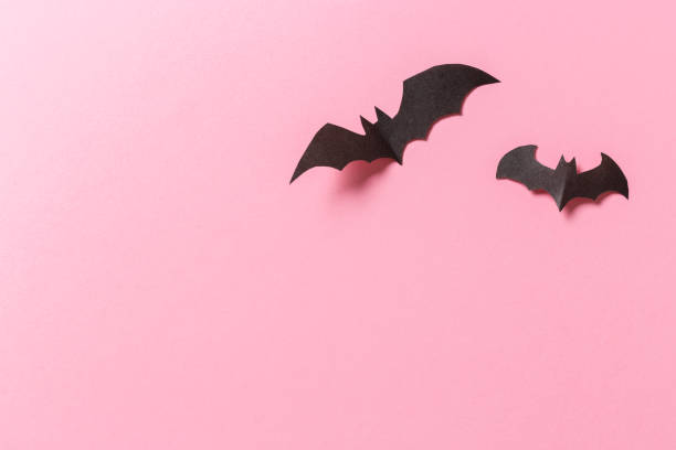 istock Halloween crafts, paper ghost on pink paper background with copy space for text. halloween concept. 1181230897