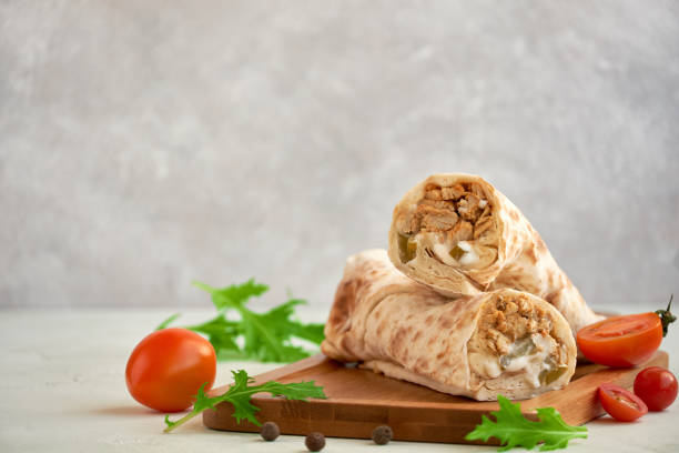 Shawarma with chicken on wooden board, closeup with space for text
