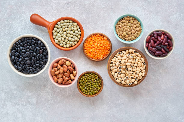 istock Legumes, lentils and beans assortment in different bowls on light stone background . Top view. Healthy vegan protein food. 1181235036