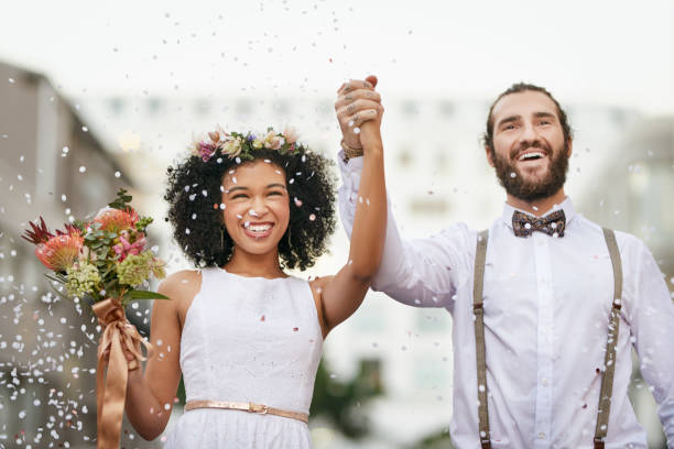 My destiny from day one Shot of a newly married young couple celebrating their wedding day against an urban background eloping stock pictures, royalty-free photos & images