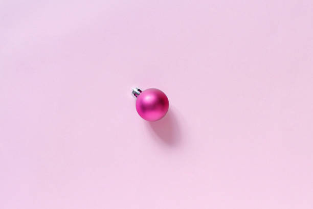 istock Pink Christmas bauble on a light pink background 1181240874