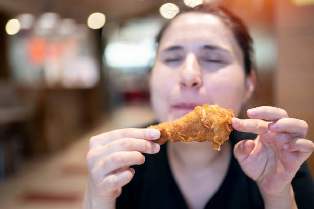 istock Young woman with fried chicken 1181245362