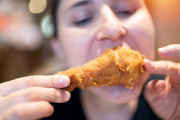 istock Young woman with fried chicken 1181245364