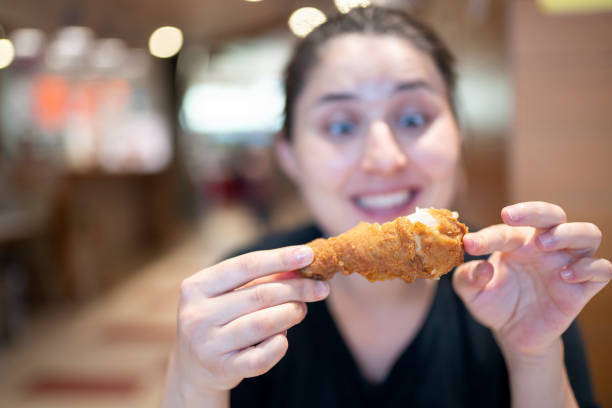 istock Young woman with fried chicken 1181245365