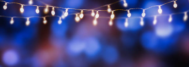 string of light bulbs on blue abstract background - twinkle lights imagens e fotografias de stock