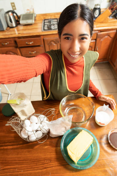 schöne junge latin hausfrau macht ein selfie - stereotypical housewife women domestic kitchen brown hair stock-fotos und bilder