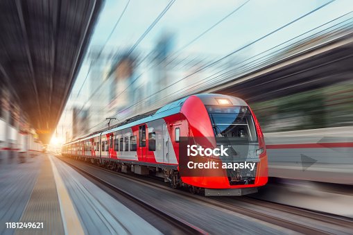 istock Electric passenger train drives at high speed among urban landscape. 1181249621