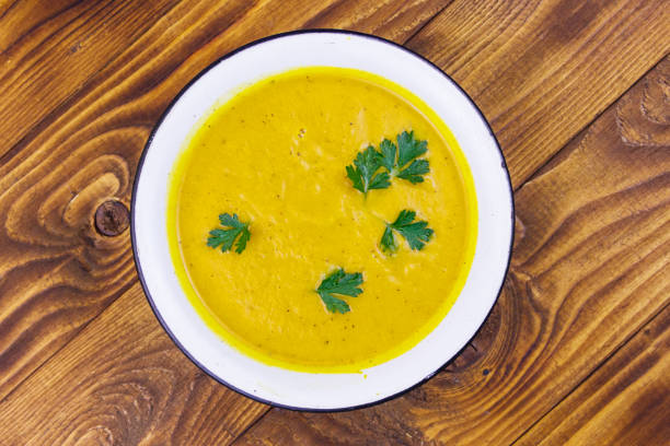 istock Pumpkin soup on a wooden table. Top view 1181251685