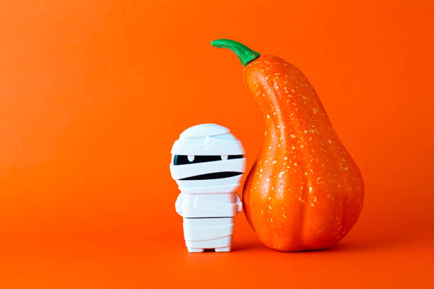 istock Orange pumpkin with mummy on orange background with copy space ,  halloween concept. 1181254713