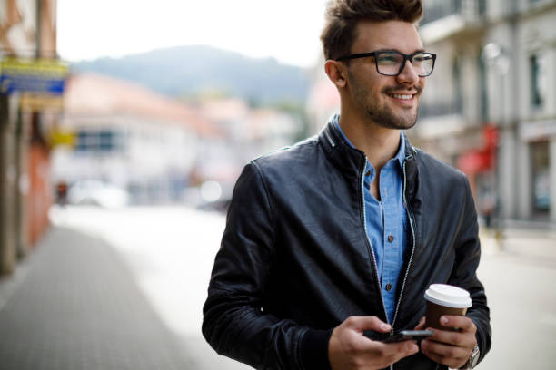 istock Smiling young man drinking coffee outdoor 1181254733
