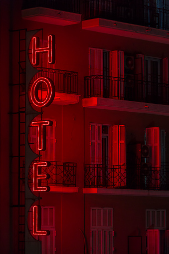 Luminous vertical hotel sign mounted on facade of hotel.