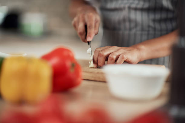 istock Woman cutting garlic. 1181255166
