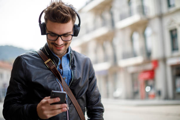 istock Portrait of smiling young man using mobile phone outdoor 1181255183