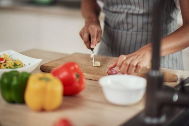istock Woman cutting garlic. 1181255334