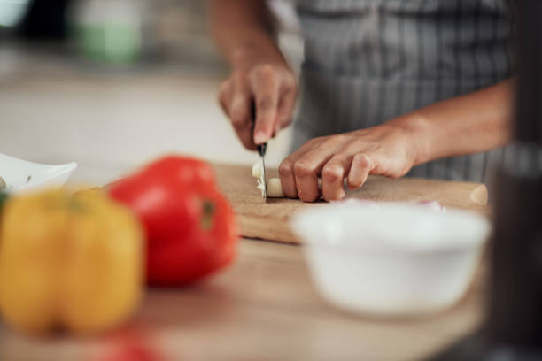 istock Woman cutting garlic. 1181256148