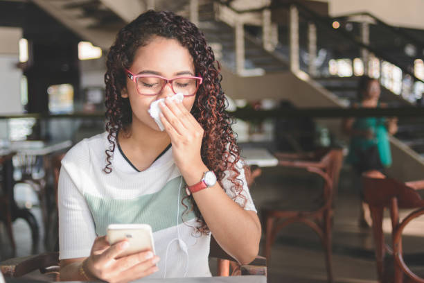 istock Young woman blowing her nose 1181256210