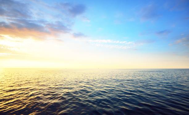 coucher du soleil dans un ciel nuageux au-dessus de la mer baltique ouverte avec des silhouettes lointaines de bateau de veri. - open sky cloudscape cloud photos et images de collection