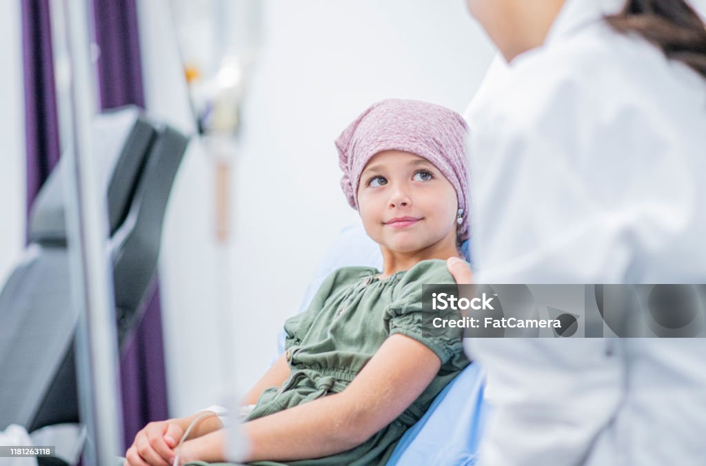 Smiling Little Girl With Cancer stock photo A little girl shares a smile with her female Doctor at her bedside Cancer - Illness Stock Photo