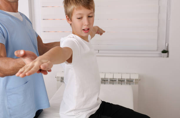 Physiotherapy for school boy , Children Poor Posture Correction, Scoliosis examination . Kinesiology treatment Physiotherapy for school boy , Children Poor Posture Correction, Scoliosis examination . Kinesiology treatment sports medicine photos stock pictures, royalty-free photos & images
