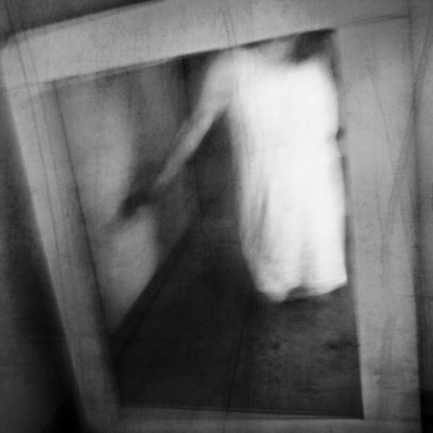 istock A ghost appears in an old vintage mirror. Phantom apparition. 1181264982