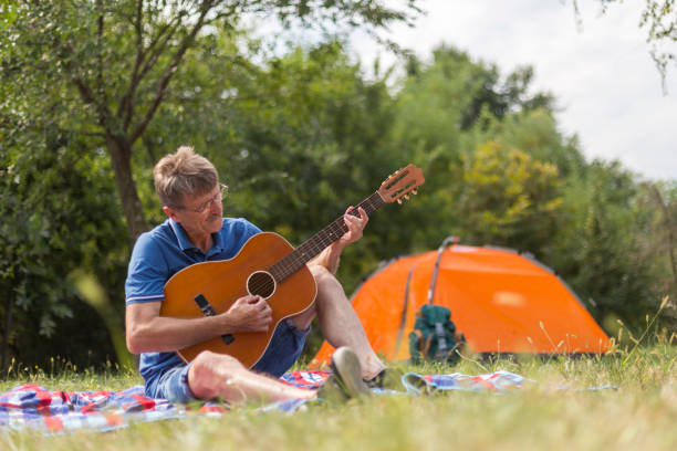 istock Man playing guitar outdoors 1181265239