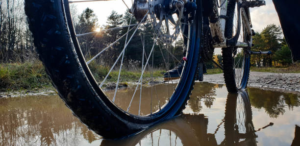 istock Bicycle in a puddle. Bicycle off-road. Off-road bicycle wheel. 1181266289