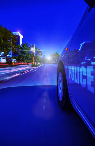Police Sedan car speeding in the night through traffic lights, motion blur, Gaborone, Botswana,
