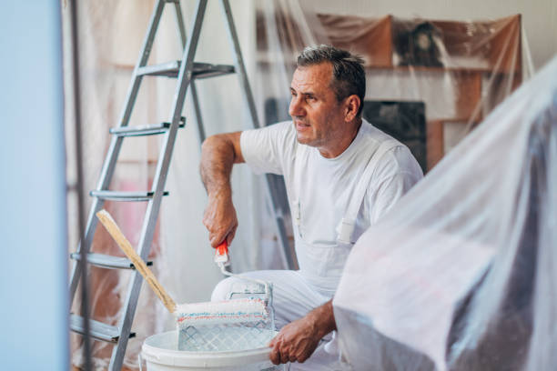 istock Senior painter painting living room 1181266621