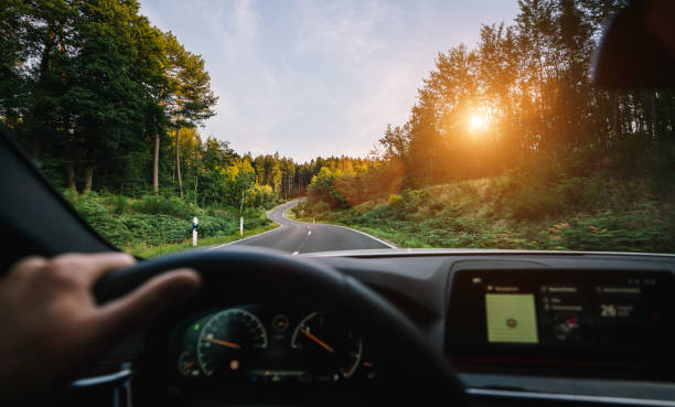 manos del conductor del coche en el volante, viaje por carretera, conducción en la carretera - perspectiva fotografías e imágenes de stock