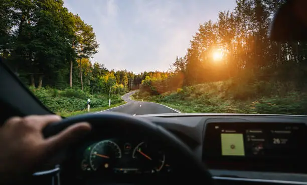 hands of car driver on steering wheel, road trip, driving on highway road