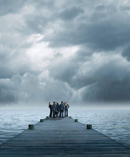 gruppo di uomini d'affari stand alla fine del molo - storm sea business uncertainty foto e immagini stock