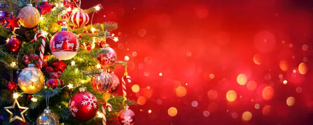 Christmas Tree With Decorated Baubles And Golden Bokeh Lights In shiny Red