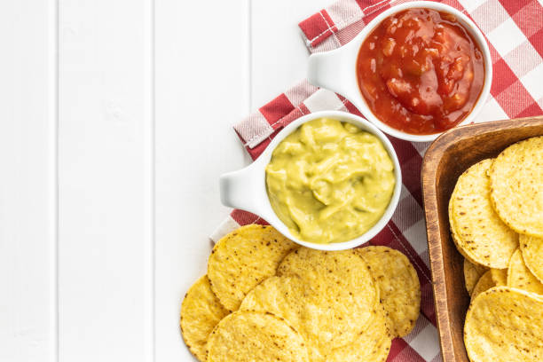 istock Corn nacho chips with avocado and tomato dip. Yellow tortilla chips and guacamole salsa. 1181279041