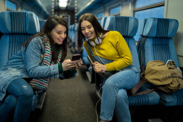 istock Two women Friends talk and laugh while traveling by train 1181280470