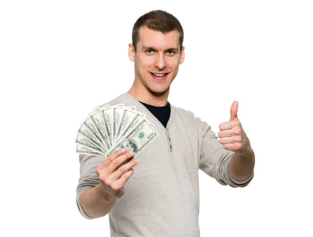 istock Happy student holding money in 100 dollar bills 1181282459