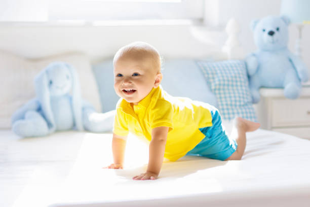 istock Baby boy playing on bed in sunny nursery 1181283788