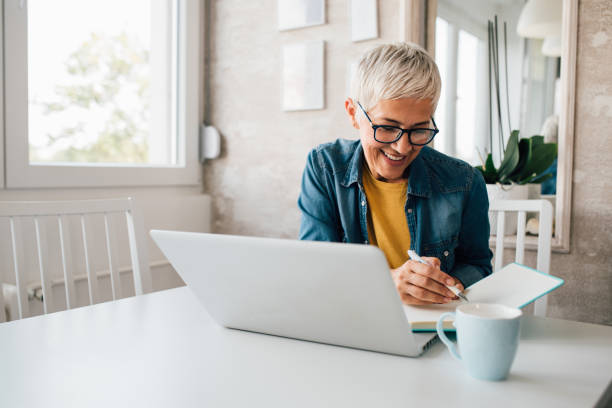 istock Mature woman doing a freelance work from her home 1181284110