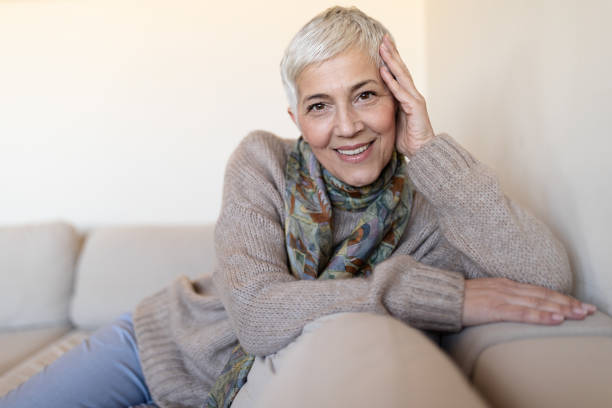 istock Happy senior woman on couch 1181284120