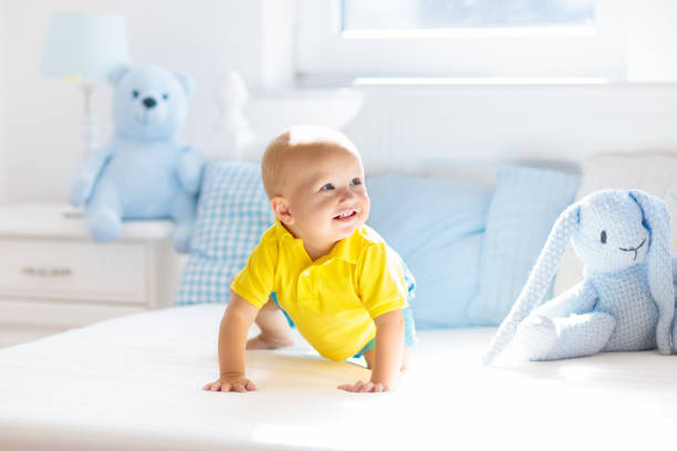 istock Baby boy playing on bed in sunny nursery 1181284125
