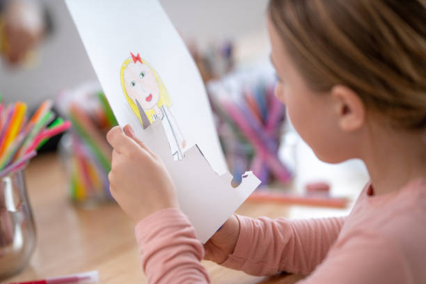 istock Schoolgirl cutting drawing 1181284344